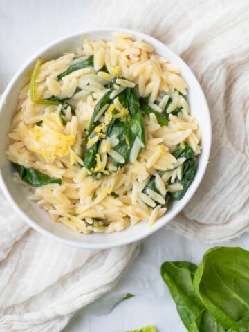 bowl of spinach lemon orzo in a white bowl