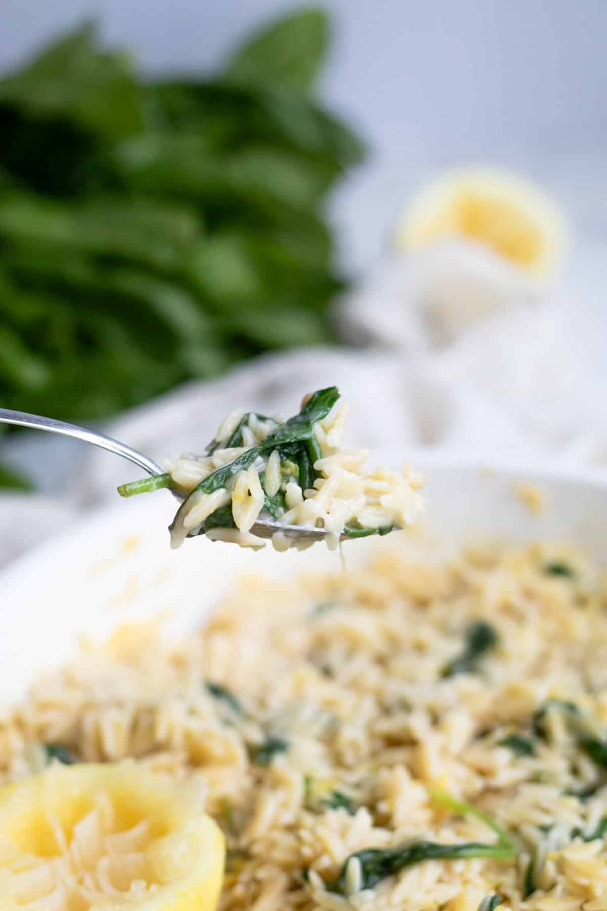 a bite of spinach lemon orzo on a fork