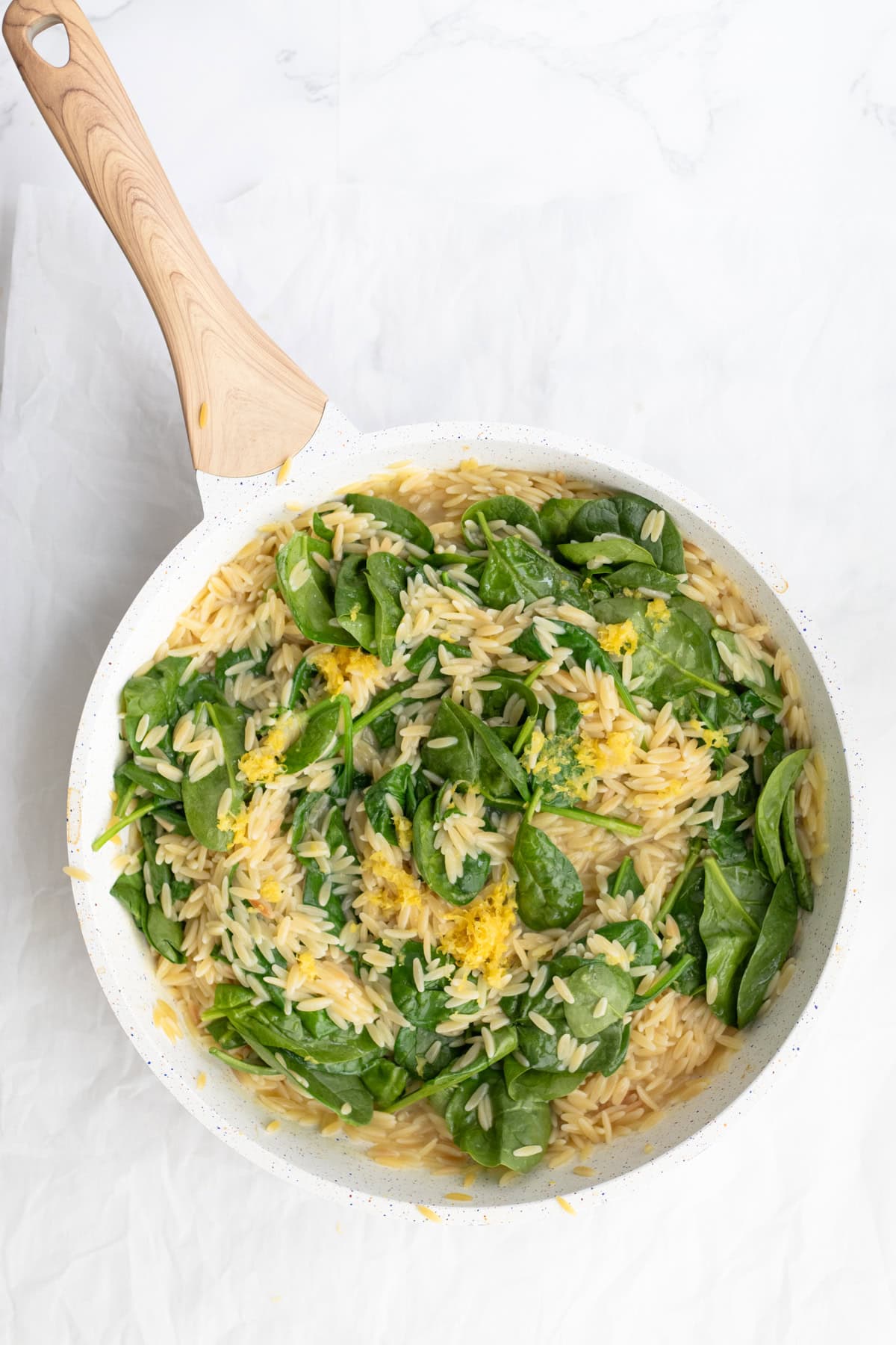 spinach wilting on top of orzo