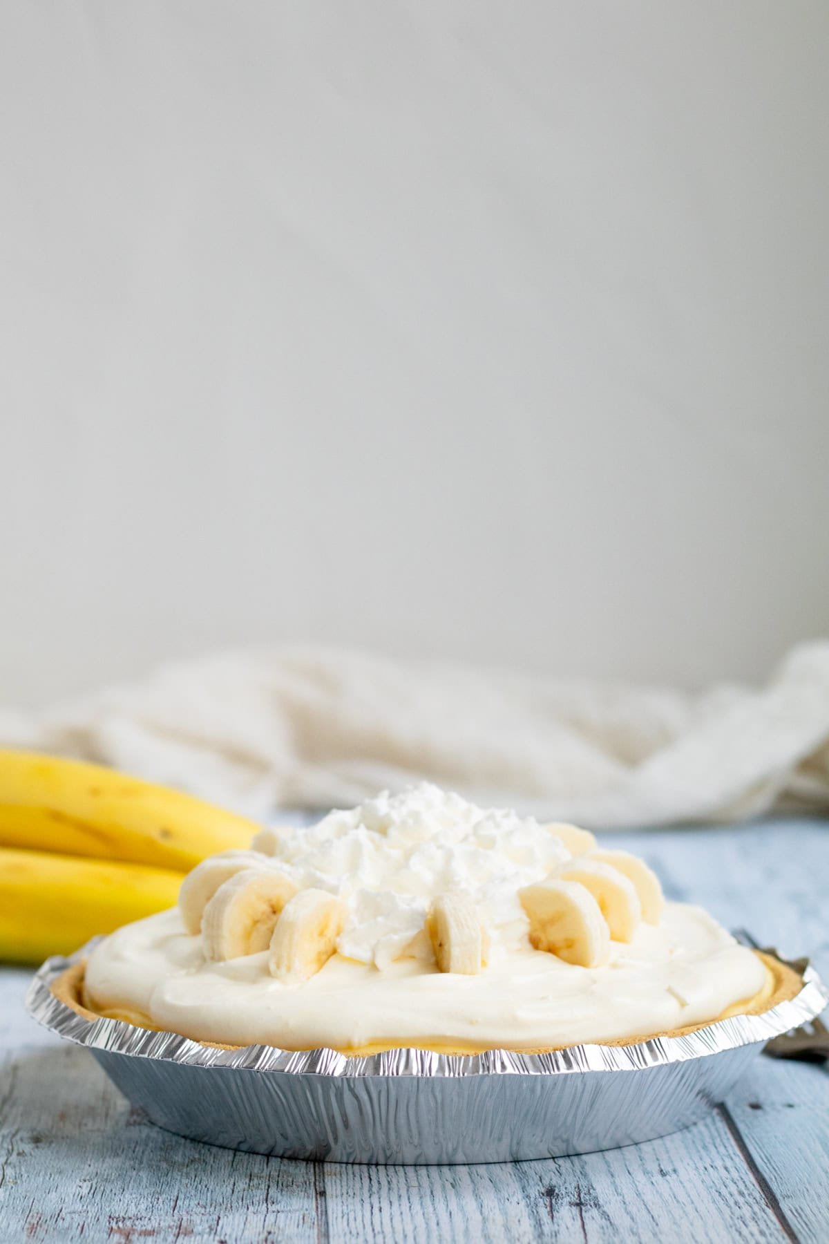 banana pudding pie garnished with whip cream and sliced bananas