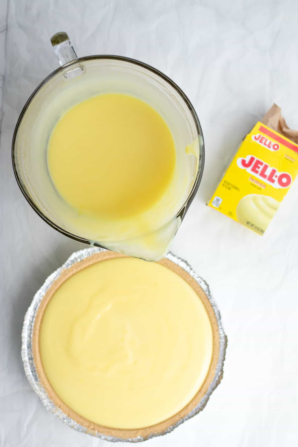 pudding being poured into a pie crust