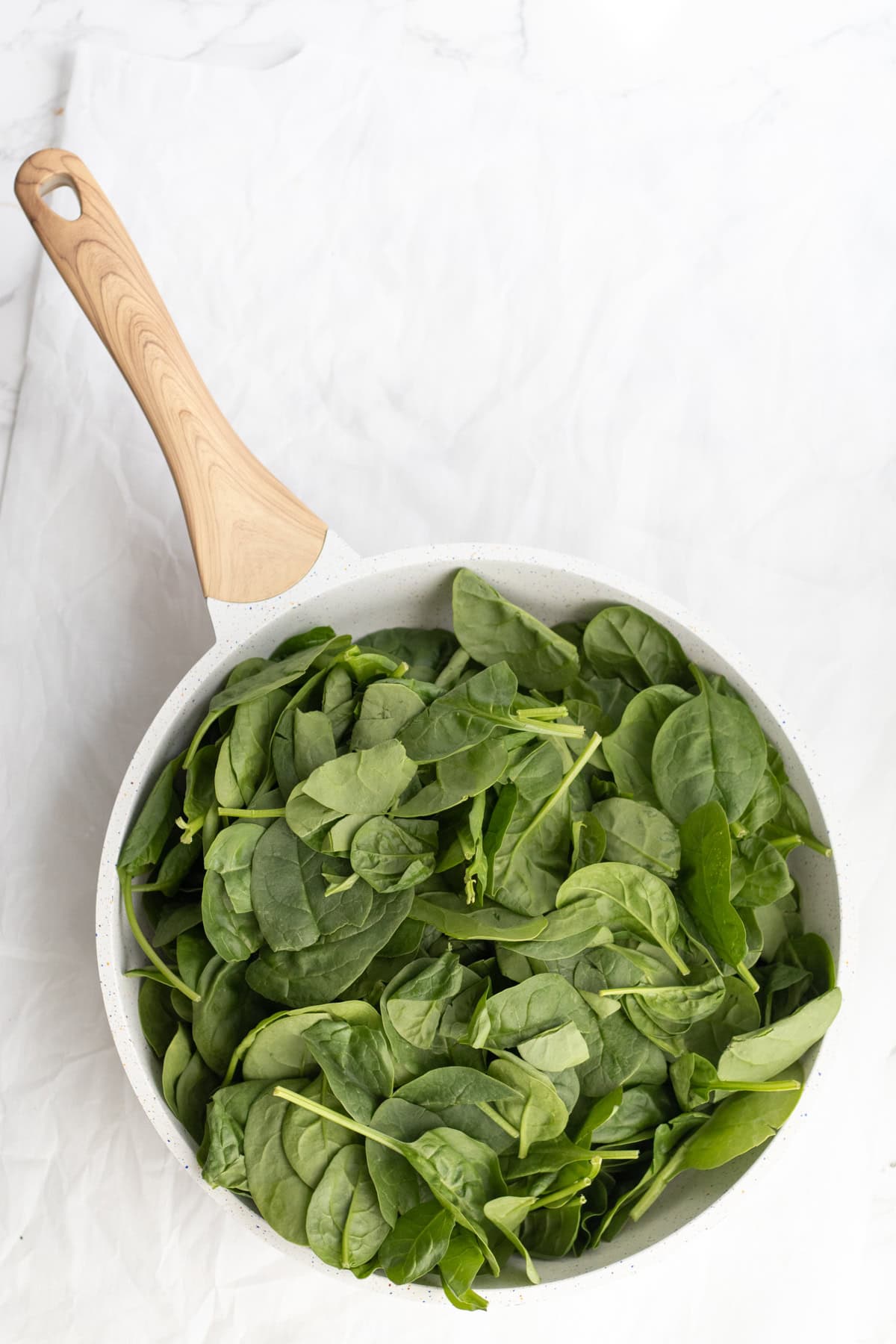 raw spinach in a frying pan