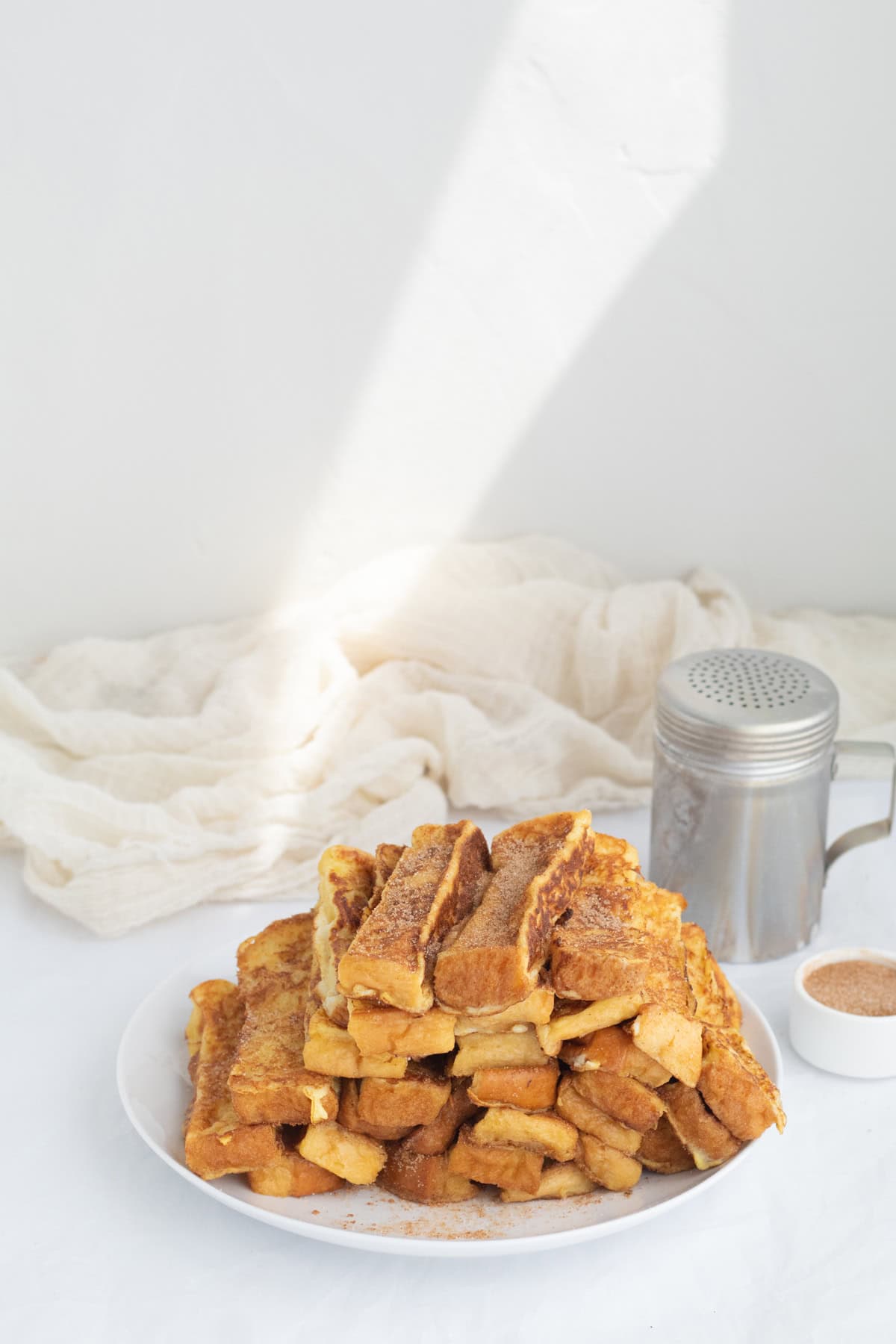 a pile of french toast sticks on a white plate