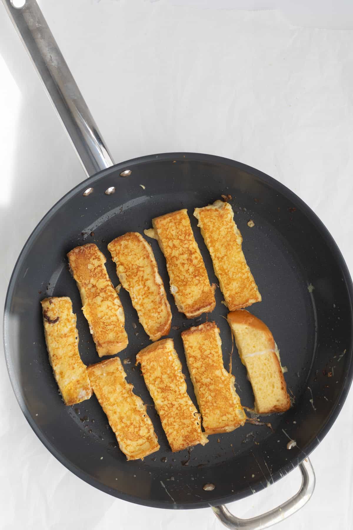 french toast sticks cooking in a pan