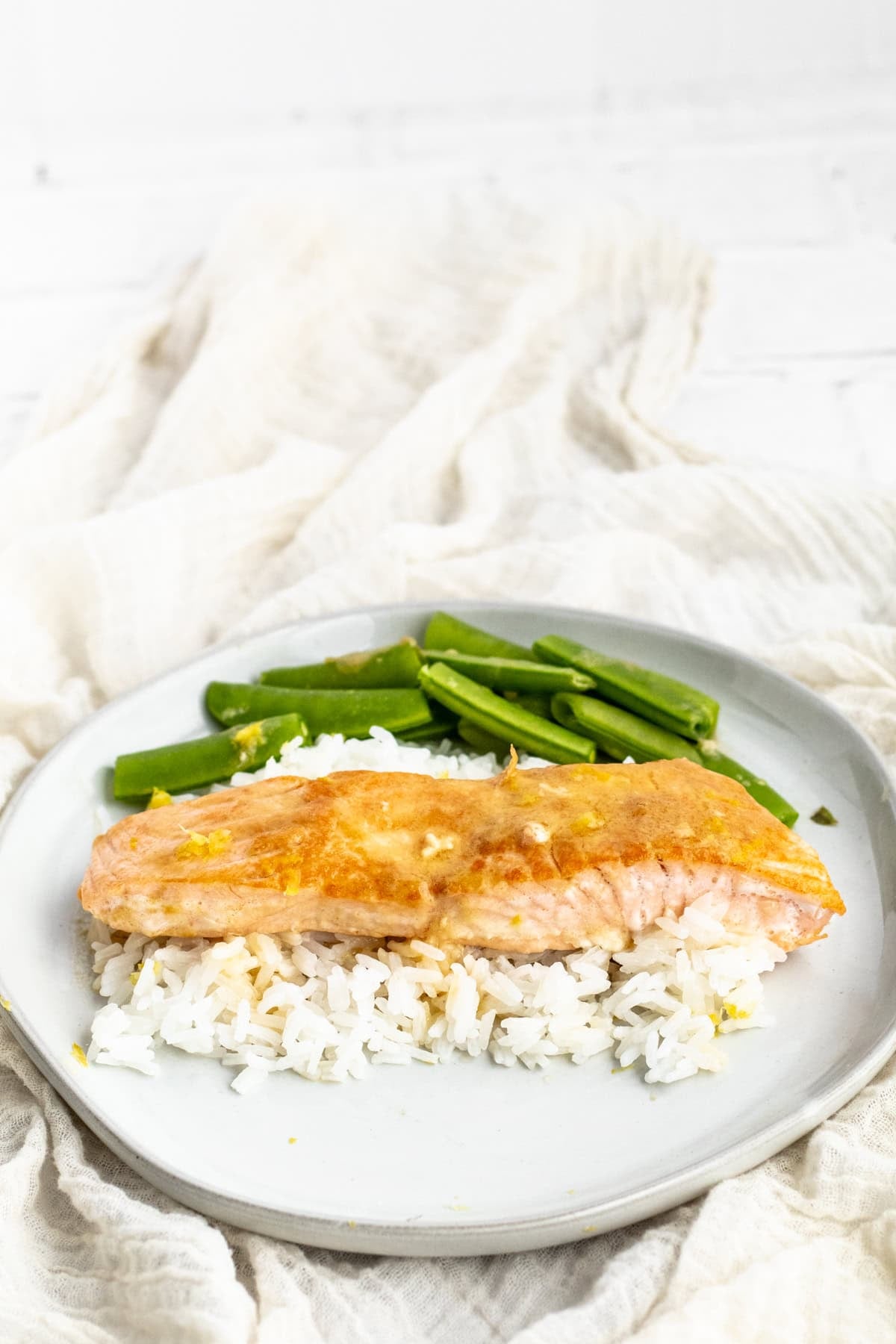 miso salmon with edamame on a plate with rice.