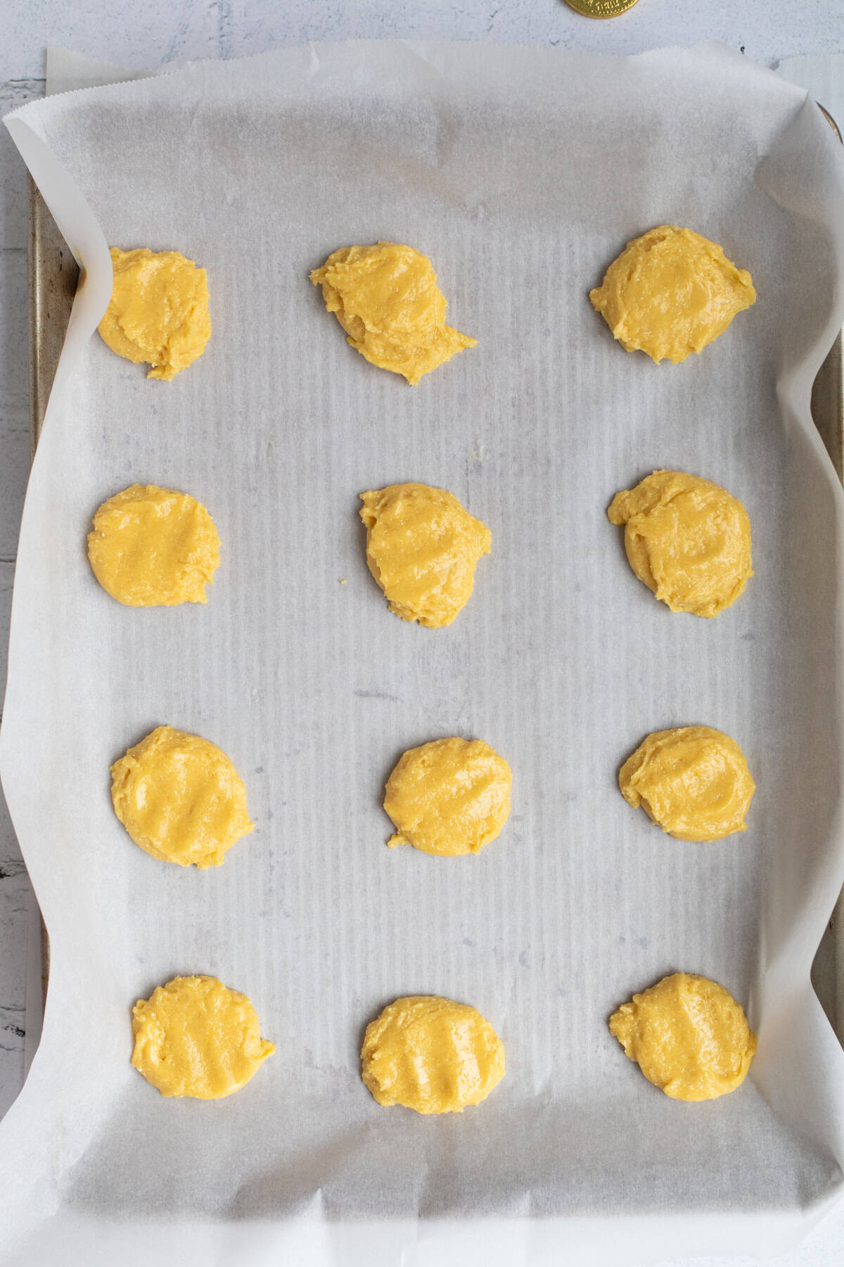cookie dough scooped onto a parchment lined baking sheet.