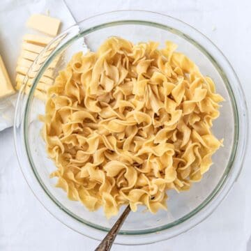 buttered noodles in a glass bowl.