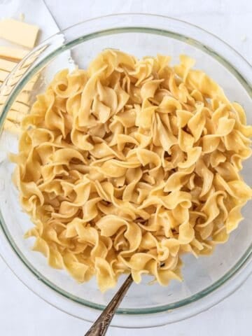 buttered noodles in a glass bowl.