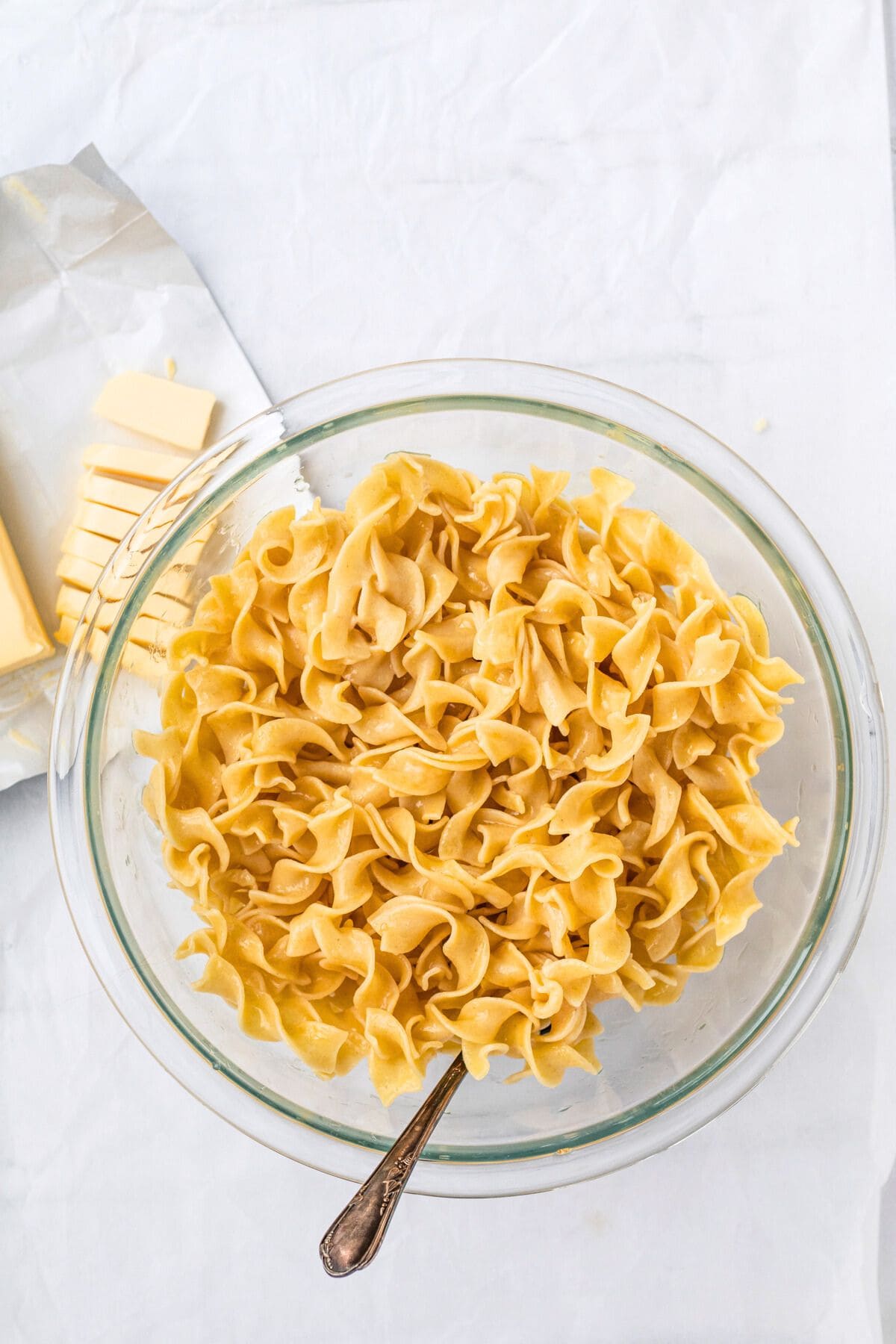 buttered noodles in a glass bowl.
