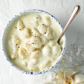 gnocchi alfredo in a serving bowl with a spoon.