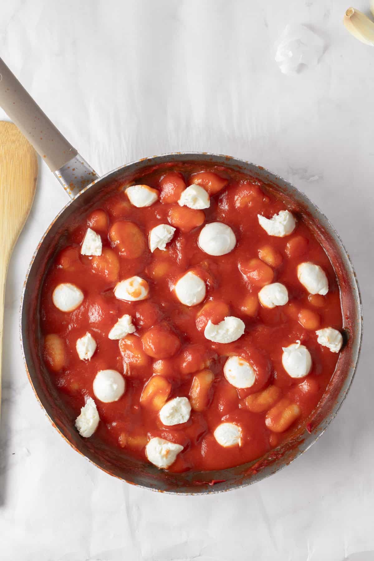 Cooked gnocchi in marinara sauce with mozzarella balls.