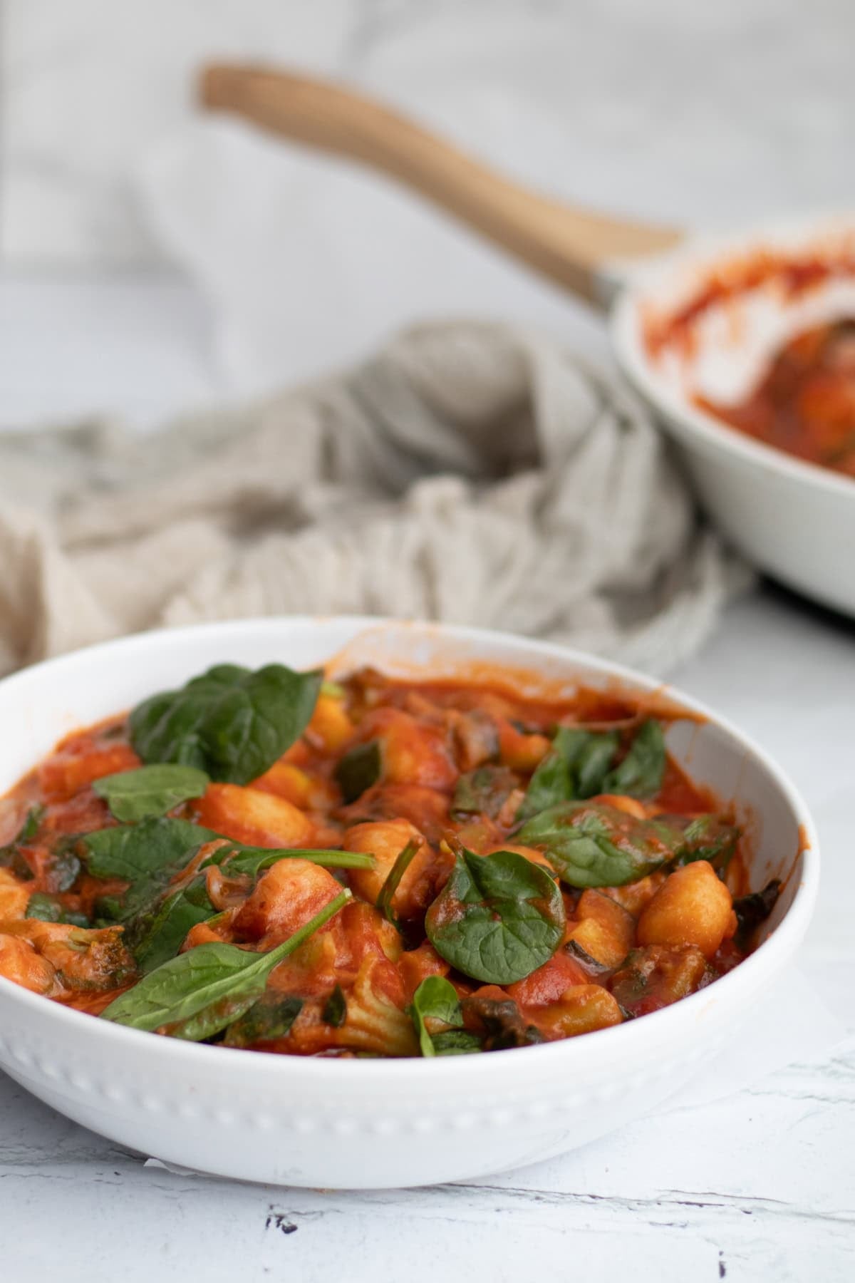 gnocchi with marinara sauce and vegetables in a serving bowl.