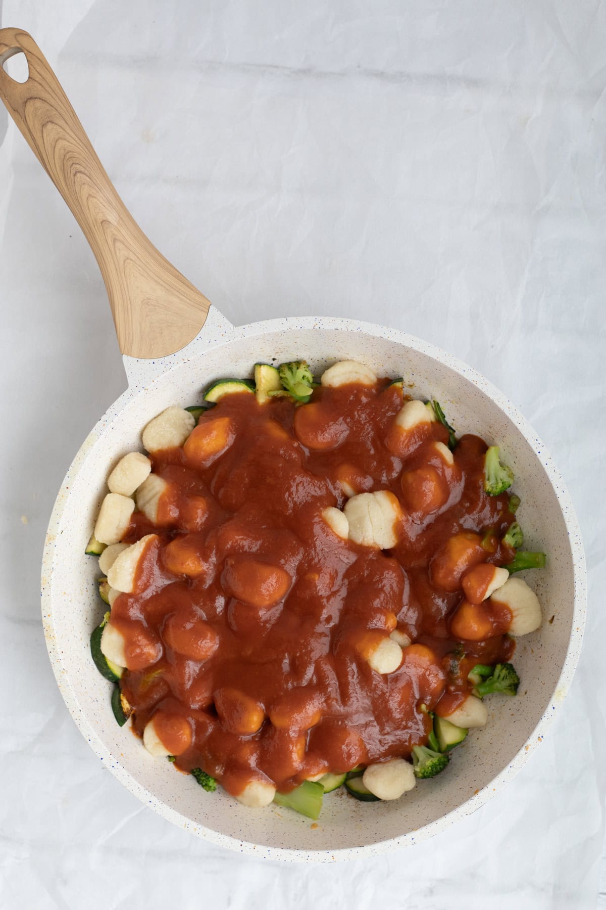 gnocchi with marinara and vegetables in a pan.