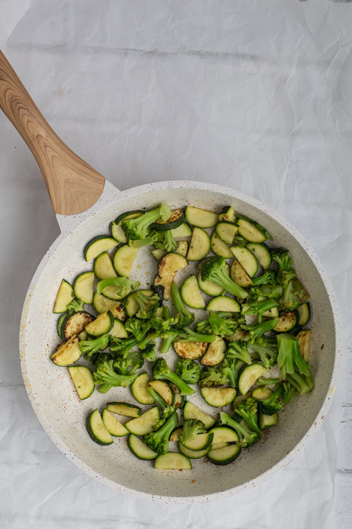 broccoli and zucchini sauteed in a pan.