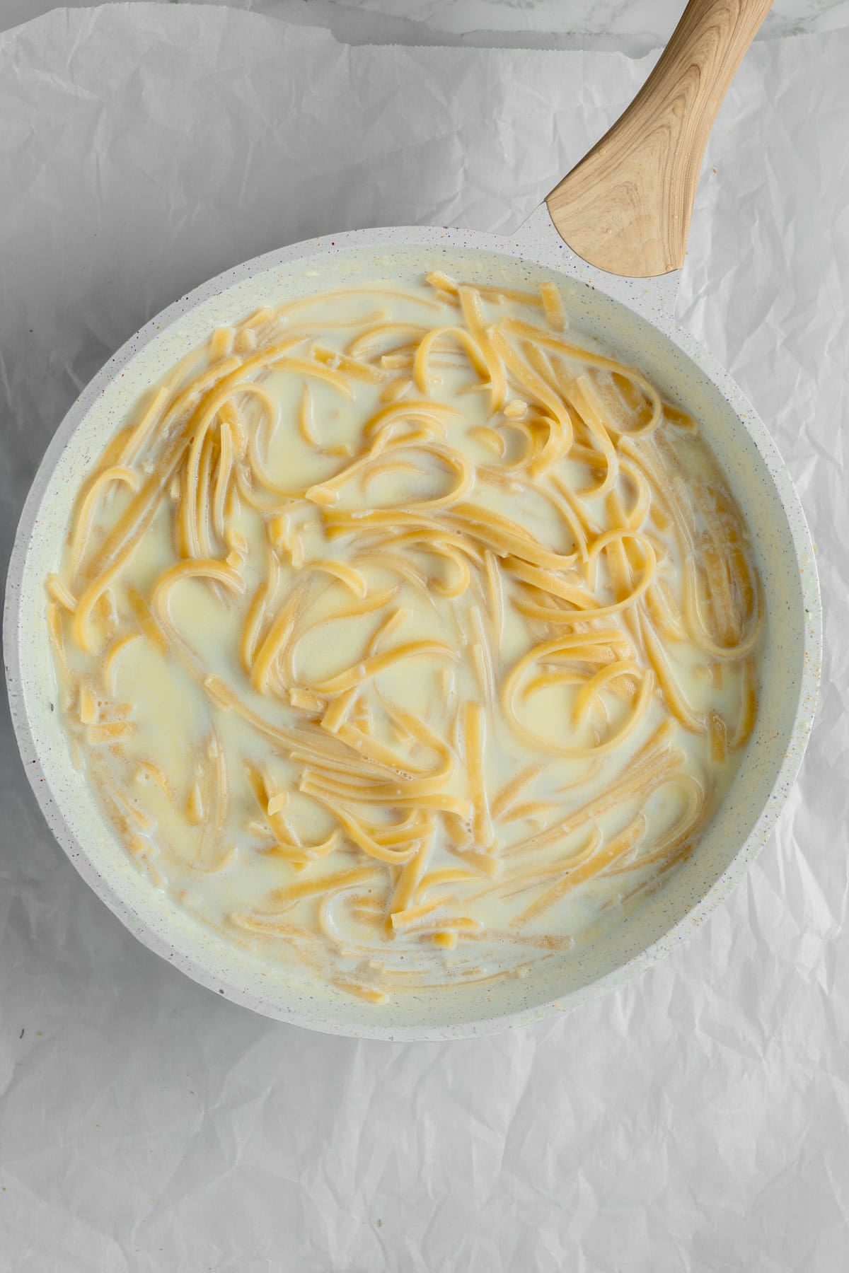 Pasta cooking in a cream sauce.