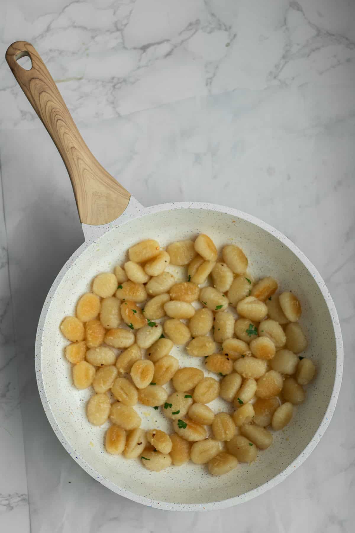 Pan fried gnocchi in a frying pan.