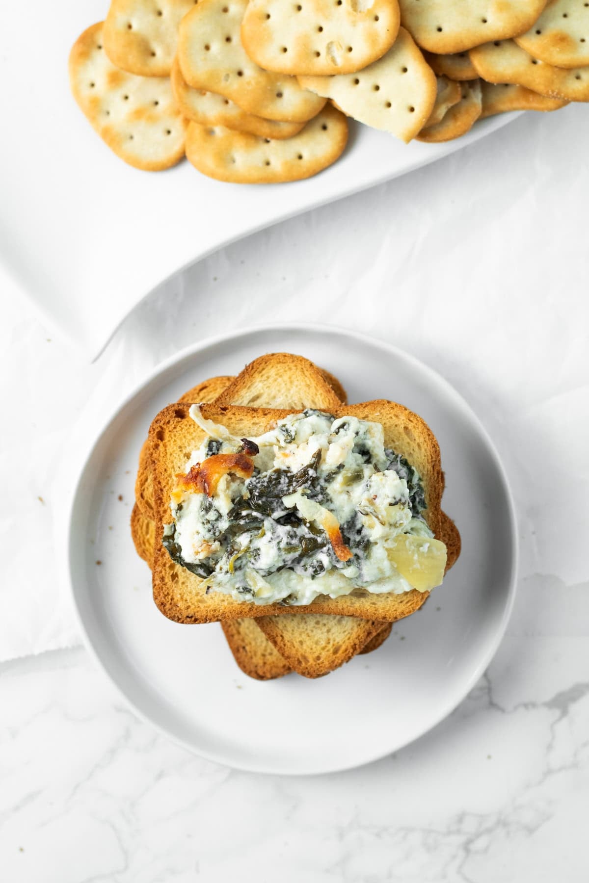 spinach artichoke dip on a piece of crostini.