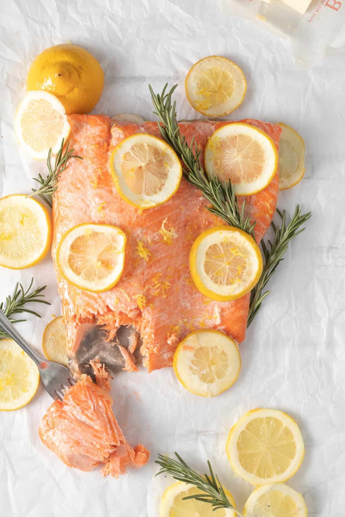 Baked lemon butter salmon with a fork taking a piece out.