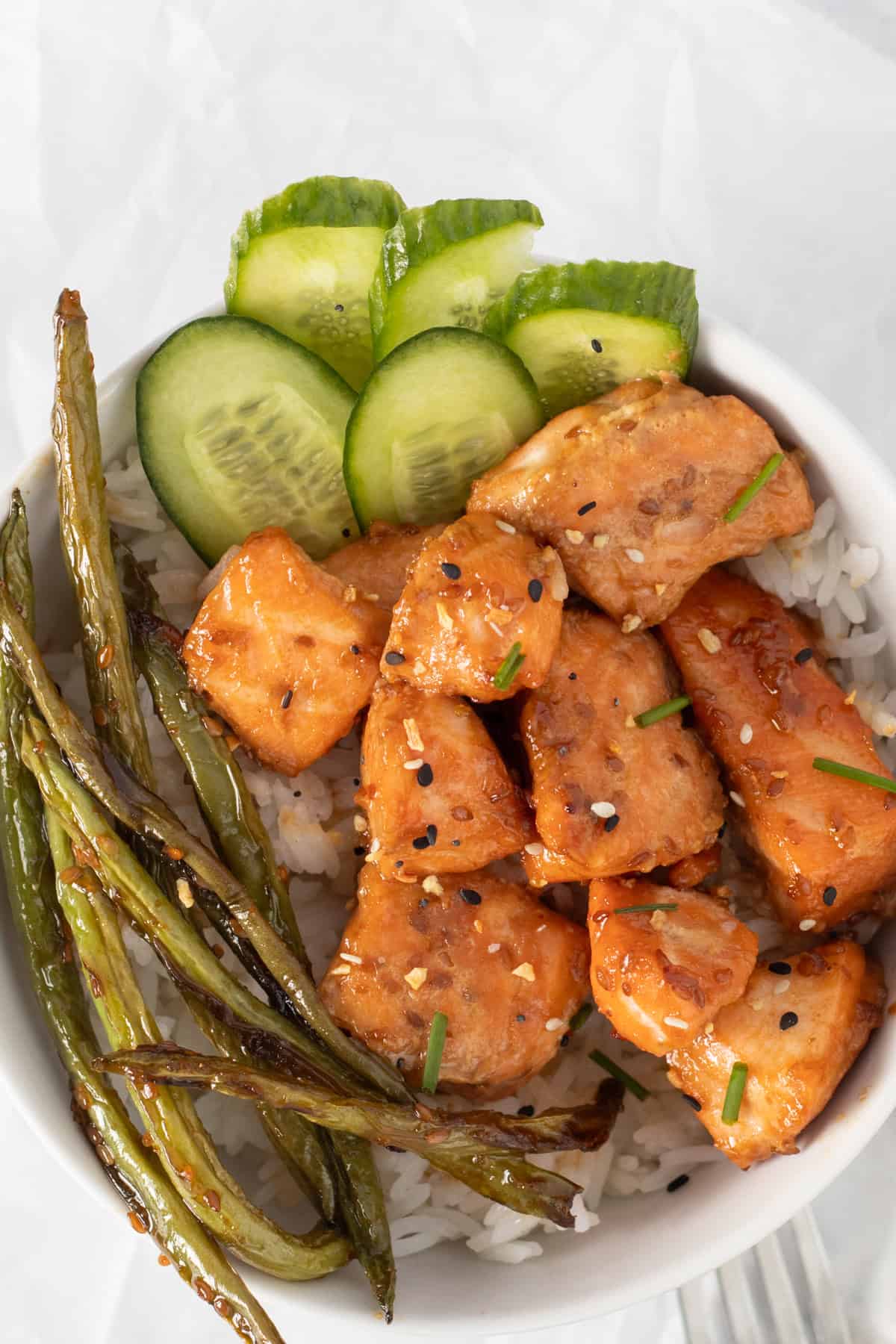 bowl with salmon bites and green veggies over rice.