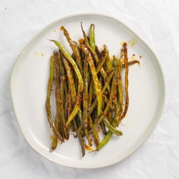teriyaki green beans on a white plate.