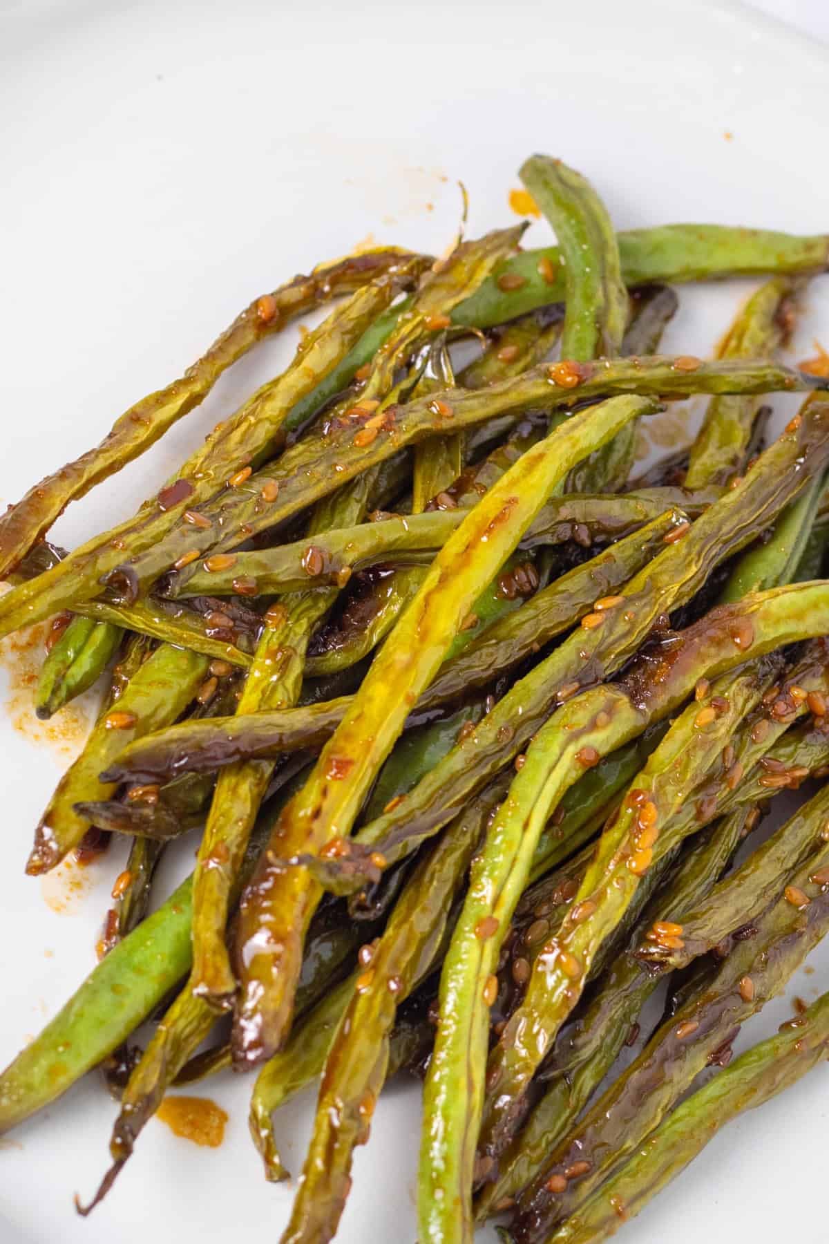 teriyaki green beans on a white plate.