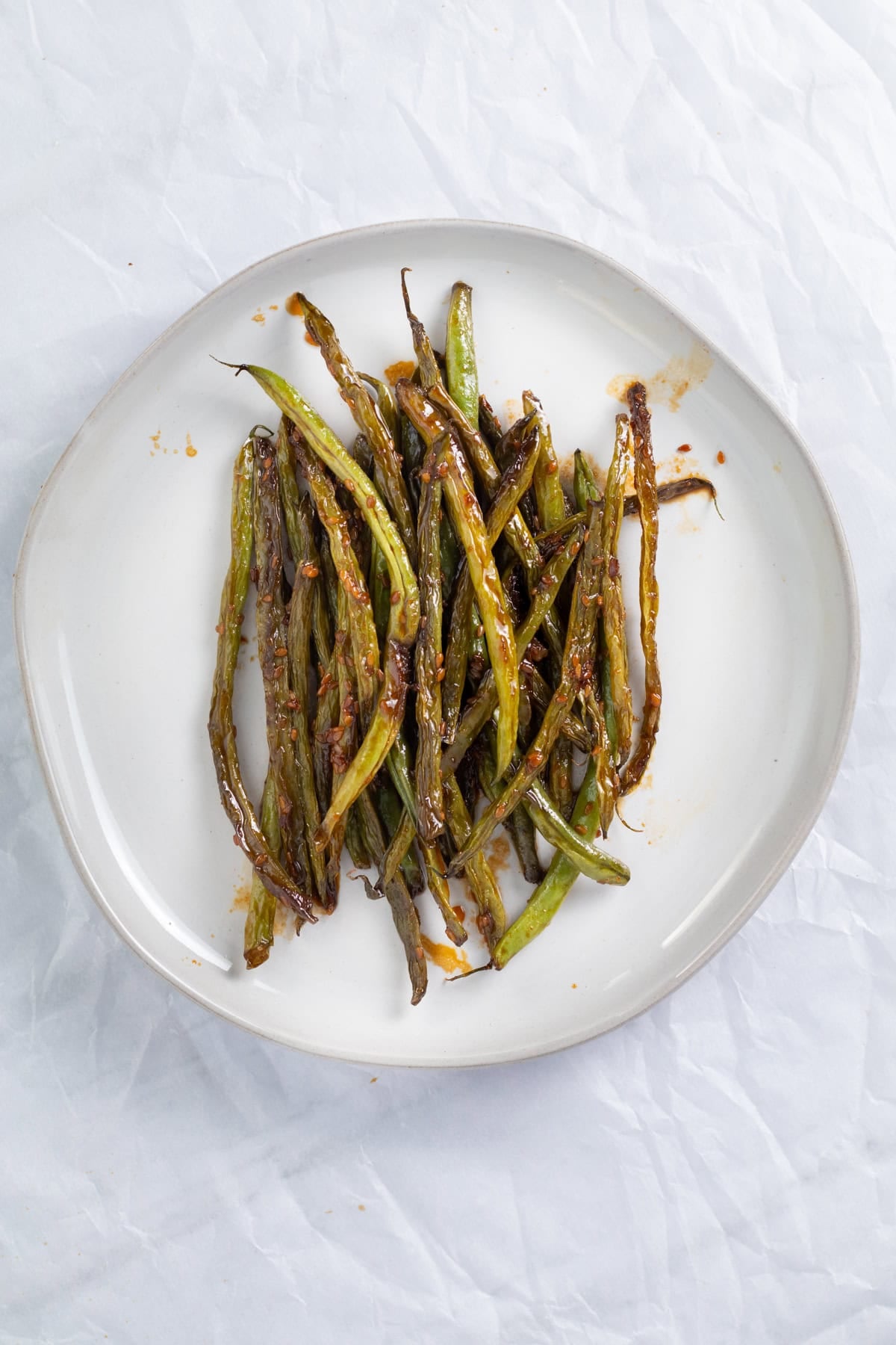 teriyaki green beans on a white plate.