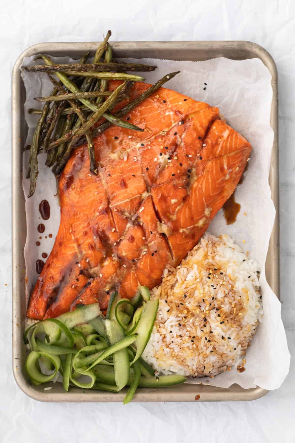 Teriyaki Salmon on a sheet pan with rice and vegetables.