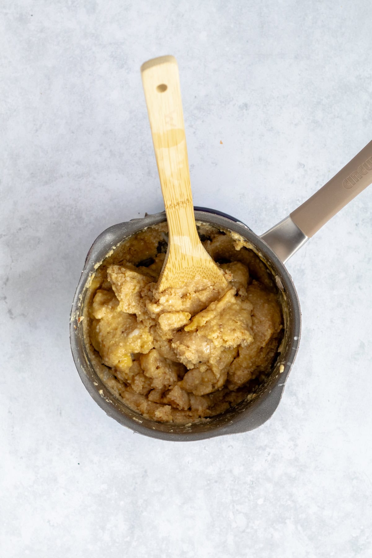 eggs mixing into matzo meal batter with twooden spoon.
