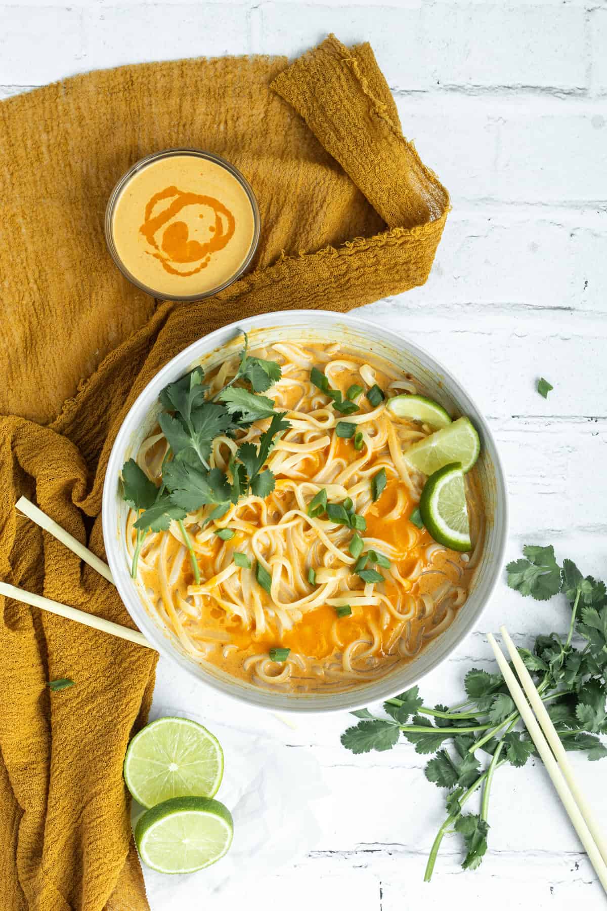Red curry sauce on udon noodles and in a small bowl to the side.