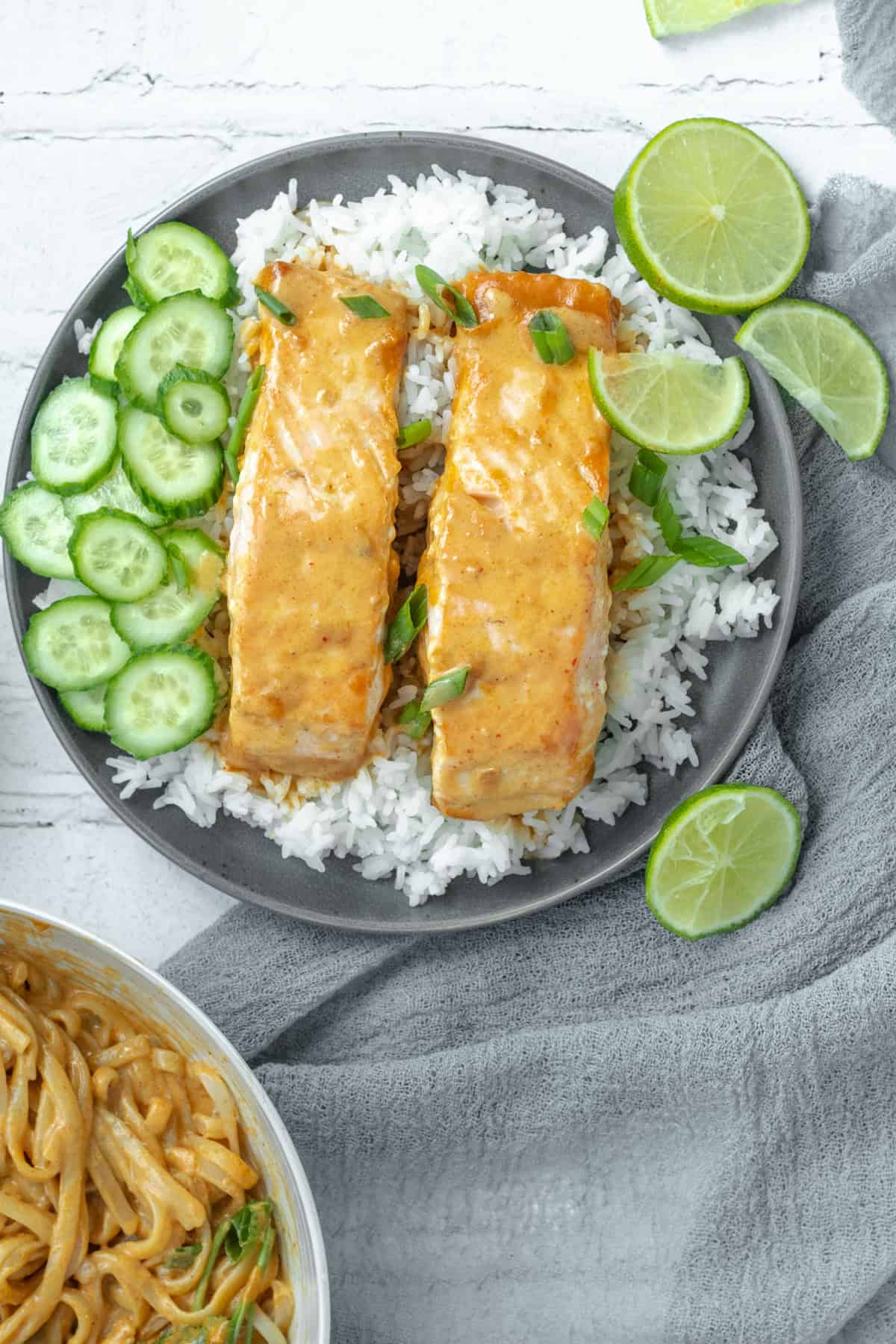 two pieces of pan seared salmon on a bed of rice with thai curry sauce.