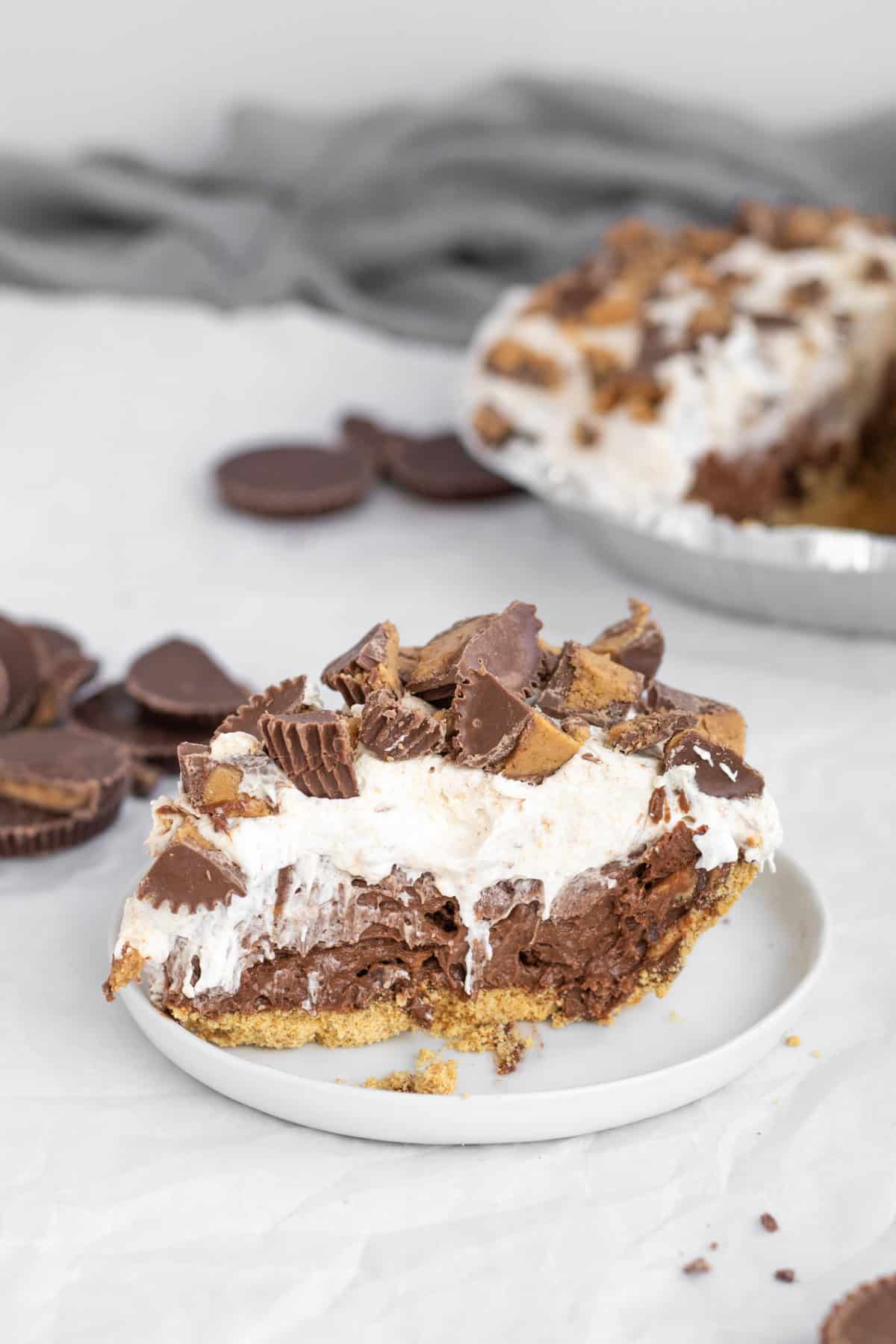 chocolate peanut butter cup pudding pie on a white plate.