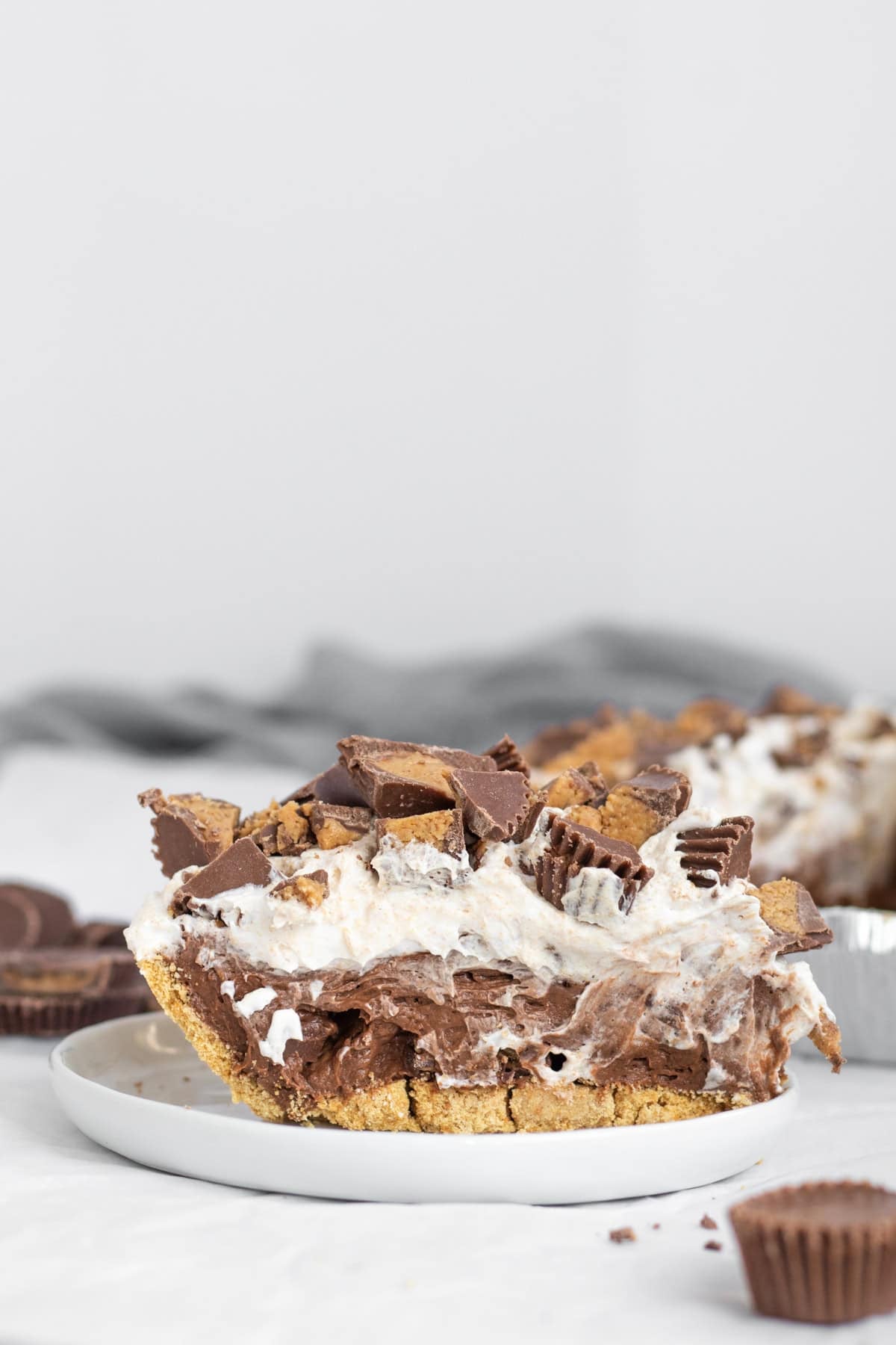 side view of a slice of chocolate peanut butter cup pudding pie.