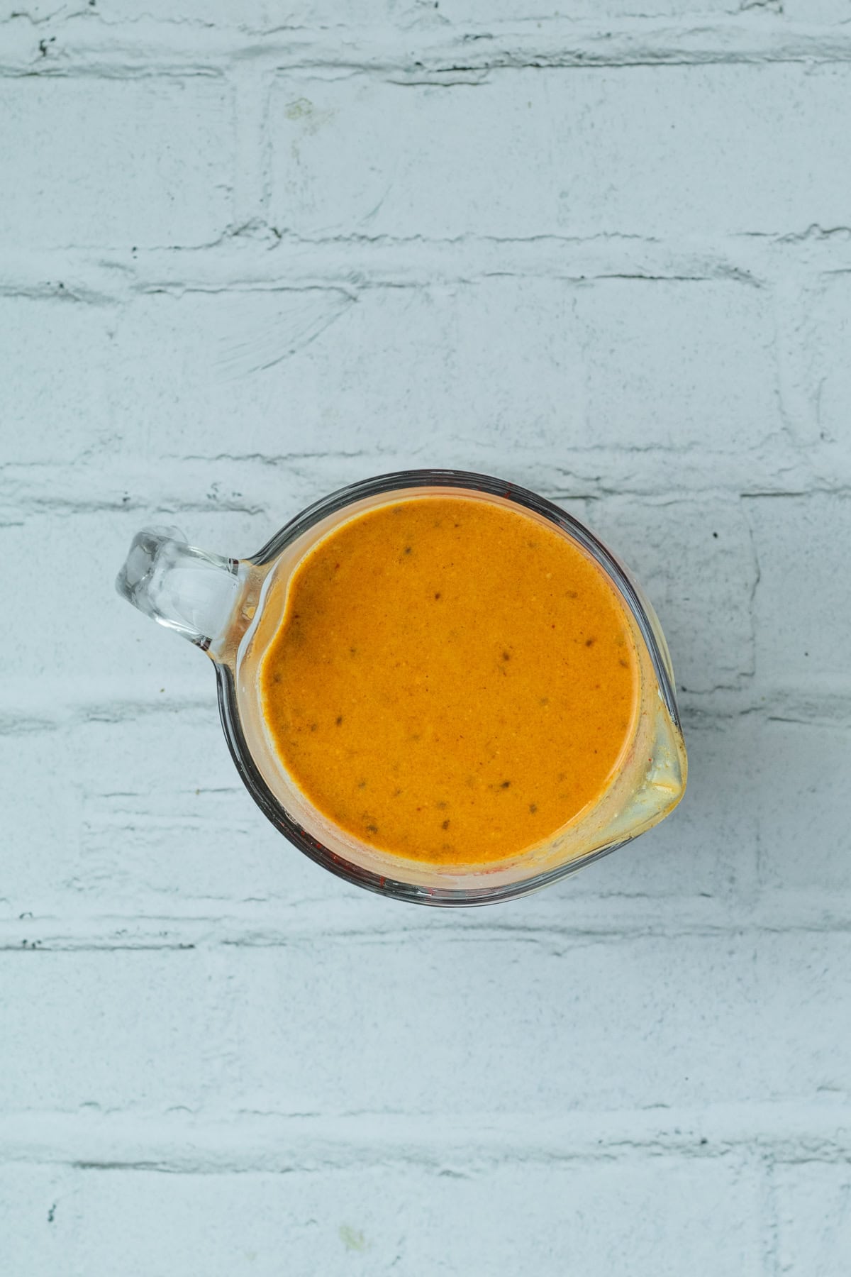 thai red curry sauce in a measuring cup.